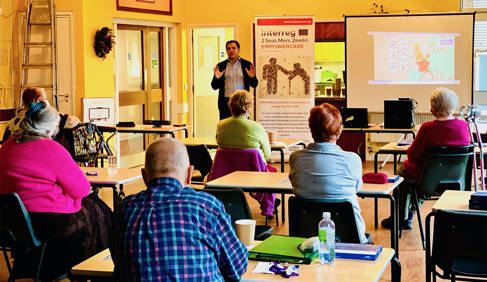 Dr Theo Fotis talking to a room of people in chairs