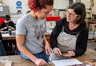 Student in a workshop with a technician