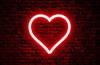 Neon heart on brick wall