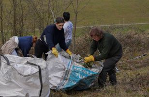 Volunteers at chalk grassland restoration bagging up debris